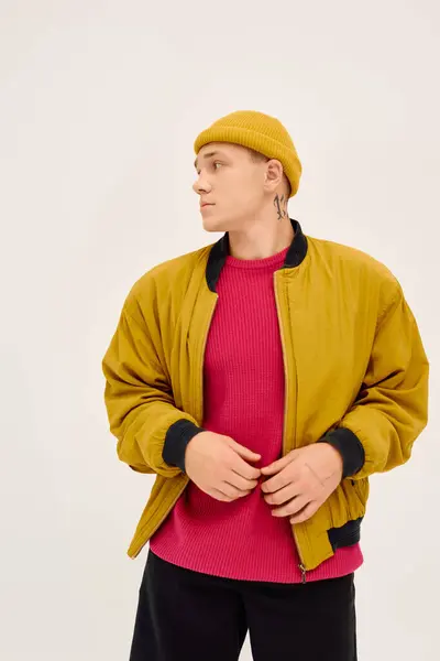 Bello giovane uomo posa con fiducia in abbigliamento alla moda, irradiando stile e fascino. — Foto stock