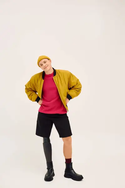 Um jovem com uma perna protética posa confiantemente em roupas da moda contra um pano de fundo neutro. — Fotografia de Stock