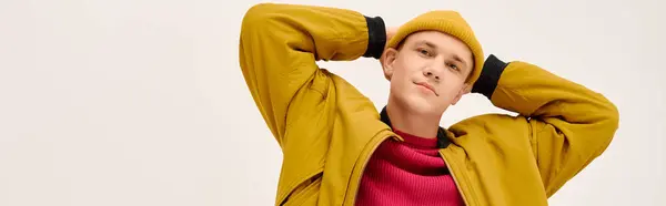 Stylish young man poses effortlessly in a vibrant outfit against a neutral backdrop, banner — Stock Photo
