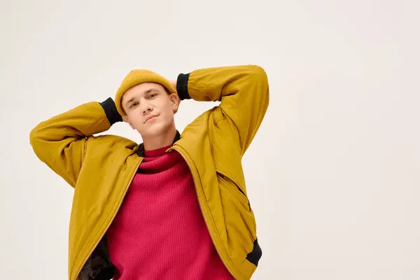 Bello giovane mostra vestito elegante contro uno sfondo minimalista studio. — Foto stock