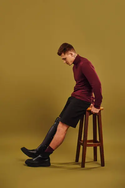 Um jovem elegante posa confiantemente em trajes da moda enquanto mostra sua perna protética. — Fotografia de Stock