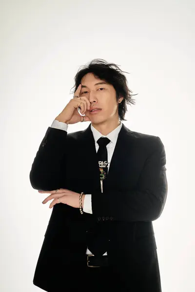 A stylish young Asian man exudes charisma in a chic setting. — Stock Photo