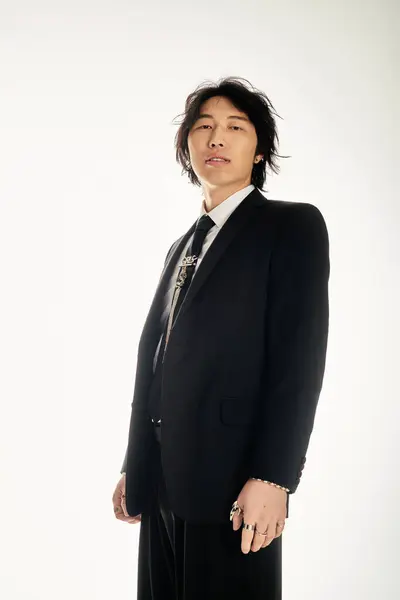 A handsome young asian man poses confidently, showcasing his trendy fashion and urban appeal. — Stock Photo
