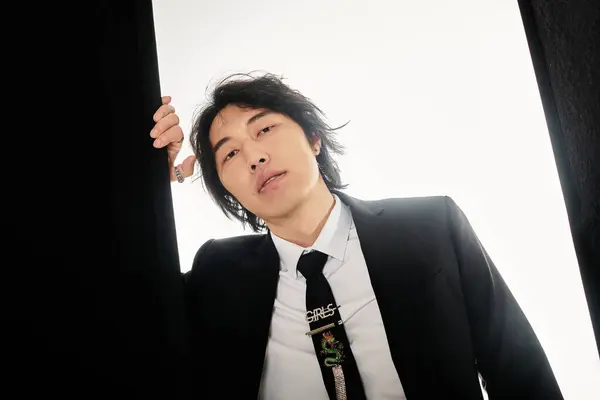Stylish young Asian man shows off his fashion sense in a trendy setting. — Stock Photo
