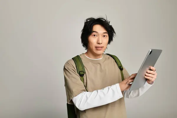 Trendy young man interacts with his tablet, showcasing a fashionable look and youthful vibe. — Stock Photo