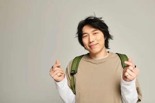 Handsome young man with a modern look radiates confidence while posing casually indoors. — Stock Photo