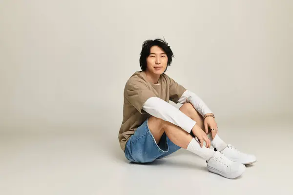Young man casually poses in a chic studio, showcasing contemporary fashion trends. — Stock Photo