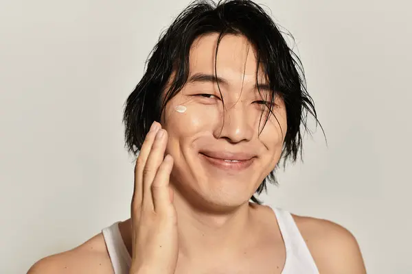 Stylish young Asian male enjoys a moment of self care while showcasing modern youth culture. — Stock Photo