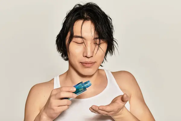 Handsome young man with stylish hair showcases his skincare routine in a contemporary environment. — Stock Photo