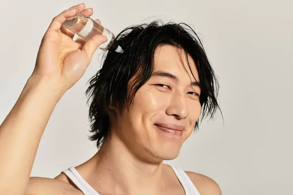 Selbstbewusster junger asiatischer Mann frisiert seine Haare und präsentiert seinen trendigen Look. — Stockfoto