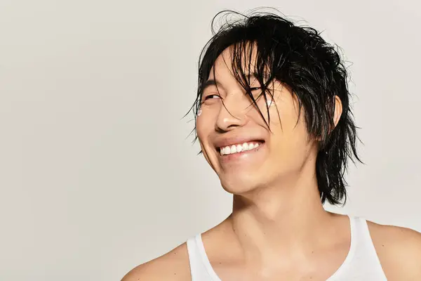 A young asian man showcases his handsome features while posing stylishly with a big smile. — Stock Photo
