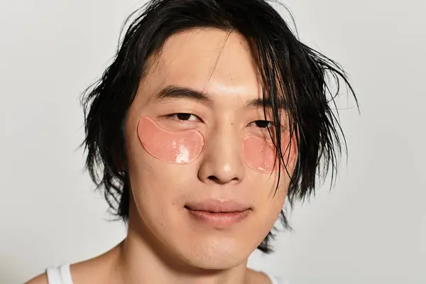 Handsome young man with eye patches enjoys a moment of relaxation in a contemporary environment. — Stock Photo