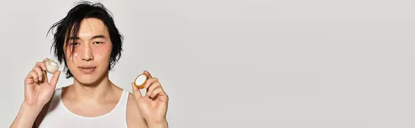 Handsome young man holds fashionable accessories while posing in a contemporary urban environment. — Stock Photo