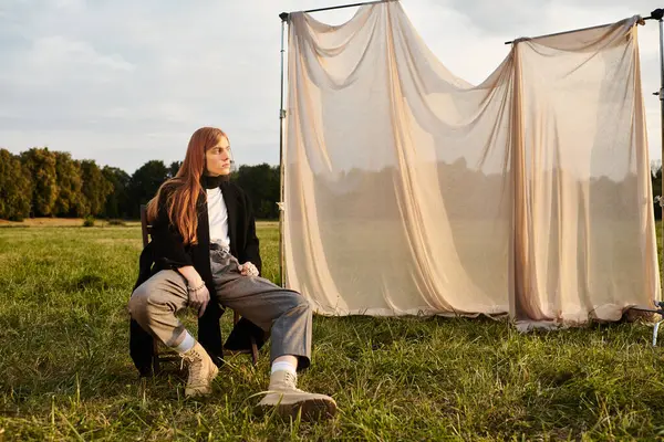 A young man in trendy clothes poses outdoors with a peaceful backdrop. — Stock Photo