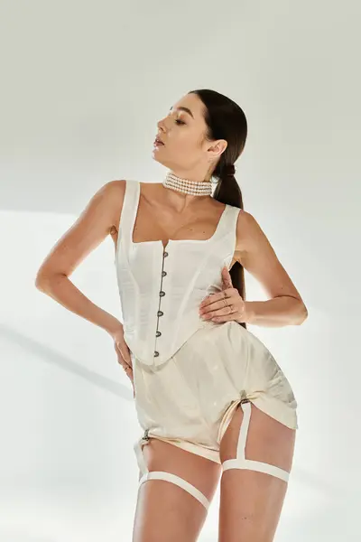 Young woman showcases flexibility and elegance in fashionable attire against a minimalist backdrop. — Stock Photo