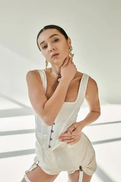 Confident young woman poses, showcasing her athleticism and modern style in soft light. — Stock Photo