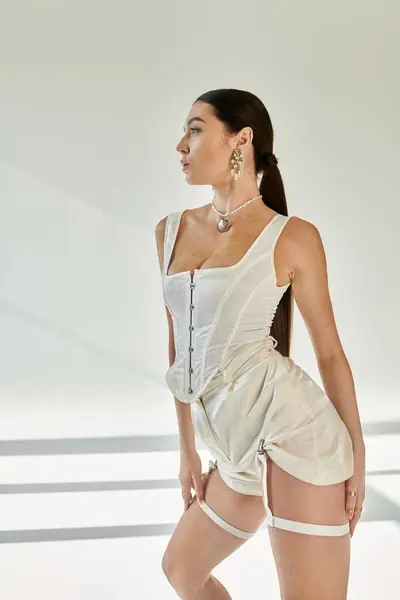 Young woman in trendy attire showcases impressive flexibility in an artistic setting. — Stock Photo