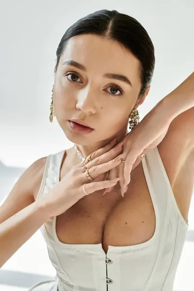 A young woman showcases her charm and flexibility in stylish attire in a minimalist space. — Stock Photo