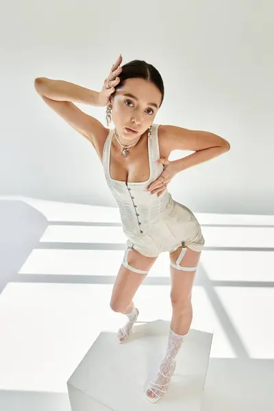 A young beautiful woman in fashionable attire displays her flexibility and charisma while posing. — Stock Photo