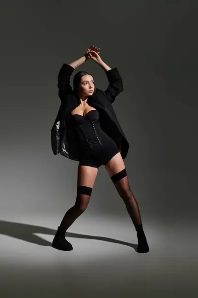 Young woman exhibits athletic grace while wearing fashionable attire in a striking pose. — Stock Photo