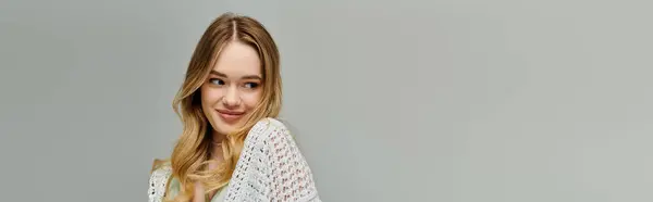Young woman embraces spring fashion with a playful smile in trendy attire surrounded by minimalism. — Stock Photo
