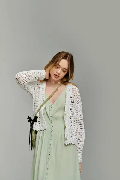 A young woman in a light dress and cardigan exudes spring vibes and effortless style. — Stock Photo