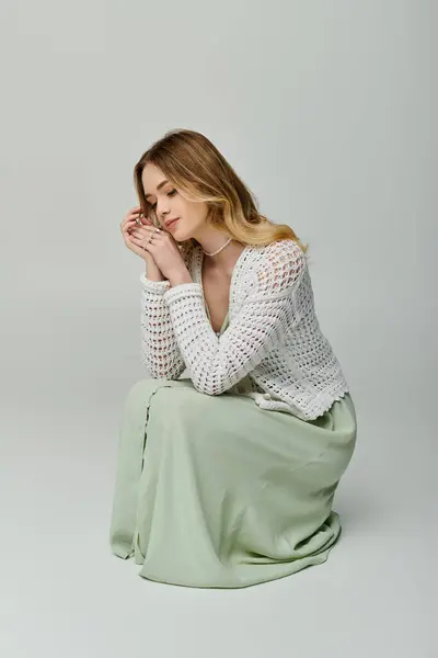Une jeune femme dans une tenue chic pose élégamment sur un fond doux. — Photo de stock