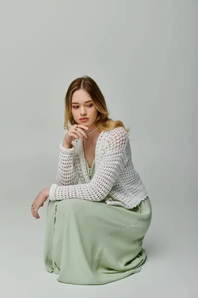 A young woman in a light green dress and white cardigan embodies spring elegance. — Stock Photo