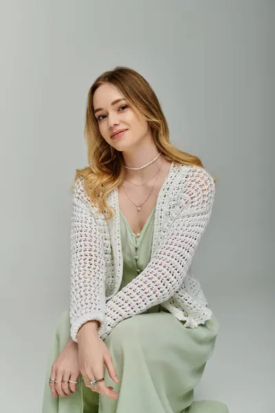 Una giovane donna elegante in un abito primaverile trasuda fiducia e fascino mentre posa. — Foto stock