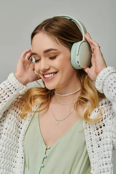 Una giovane donna in un abito elegante gode di musica, abbracciando vibrazioni e tendenze primaverili.. — Foto stock