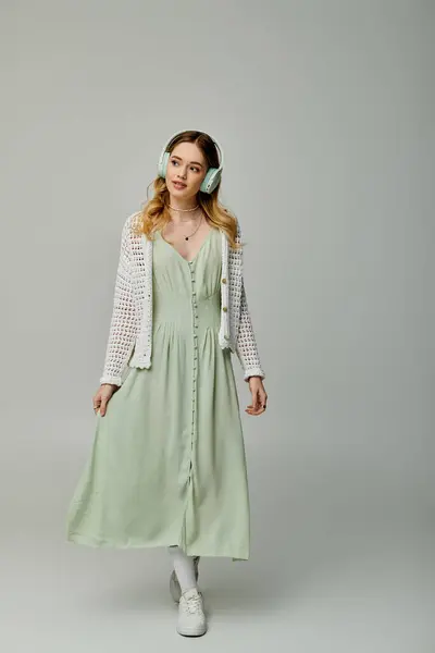 Stylish young woman walks confidently, dressed in a light green dress and cozy cardigan. — Stock Photo
