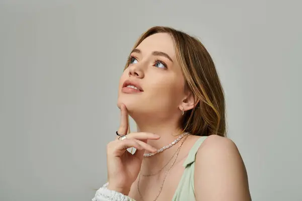 A young woman in spring attire gazes thoughtfully upwards, embracing the seasons vibe. — Stock Photo