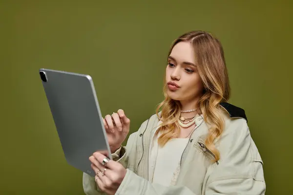 A stylish young woman uses a tablet, flaunting her trendy spring outfit and casual vibe. — Stock Photo