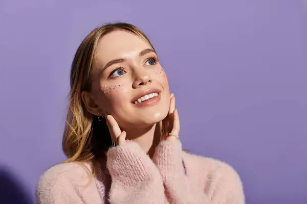 A young woman smiles with her hands on her cheeks, showcasing spring fashion. — Stock Photo