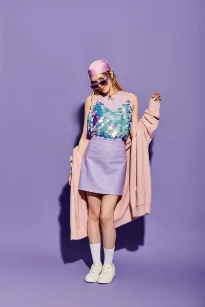 Elegante giovane donna in un top scintillante e gonna posa con fiducia su uno sfondo pastello. — Foto stock