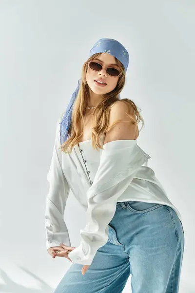 A stylish young woman showcases a trendy spring outfit, exuding youthful energy in a serene studio. — Stock Photo