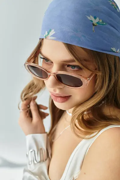 A stylish young woman exudes spring vibes in a chic outfit against a grey backdrop. — Stock Photo
