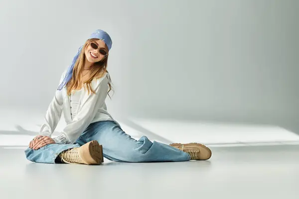 A young woman showcases a fresh spring outfit while exuding joy in a minimal studio. — Stock Photo