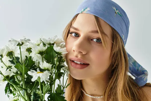 A stylish young woman enjoys the vibrant spring mood while holding fresh flowers. — Stock Photo