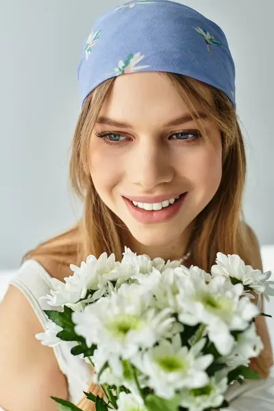 Une jeune femme élégante tient des marguerites fraîches, respirant une ambiance printanière joyeuse dans un studio moderne. — Photo de stock