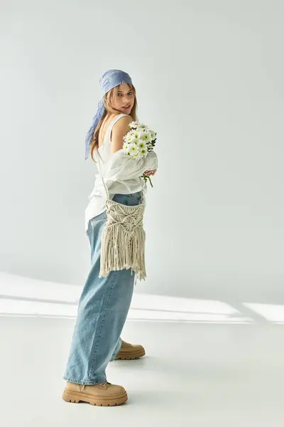 Una giovane donna alla moda si trova con fiducia in uno studio, incarnando lo spirito vibrante della primavera.. — Foto stock