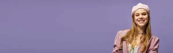 A joyful young woman models a trendy spring outfit in a purple studio, banner — Stock Photo