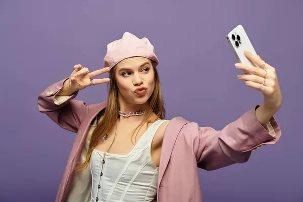 Young woman enjoys a playful moment taking a selfie in a chic spring outfit, radiating joy. — Stock Photo