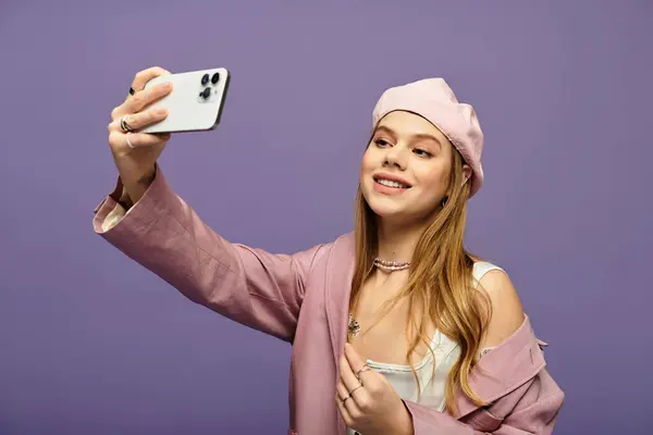 A cheerful woman in a stylish spring outfit shares a joyful moment against a purple backdrop. — Stock Photo