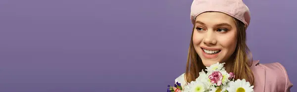 Una joven con un elegante atuendo de primavera sonríe mientras sostiene un ramo contra un telón de fondo púrpura, pancarta - foto de stock