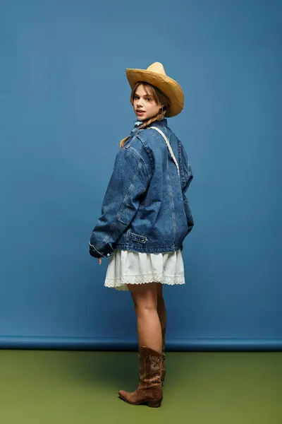 A young woman showcases a trendy denim jacket paired with a white dress, radiating spring vibes. — Stock Photo