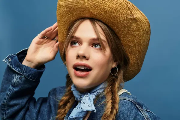 A young woman wears a denim jacket and a hat, exuding spring energy in a vibrant studio setting. — Stock Photo