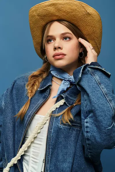 A young woman wears a trendy denim jacket with a playful expression in a bright studio setting. — Stock Photo