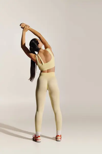 Young woman stretches to enhance flexibility and focus in a serene setting. — Stock Photo