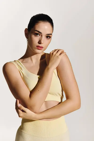 A young beautiful woman displays athletic style and poise while striking an elegant pose indoors. — Stock Photo